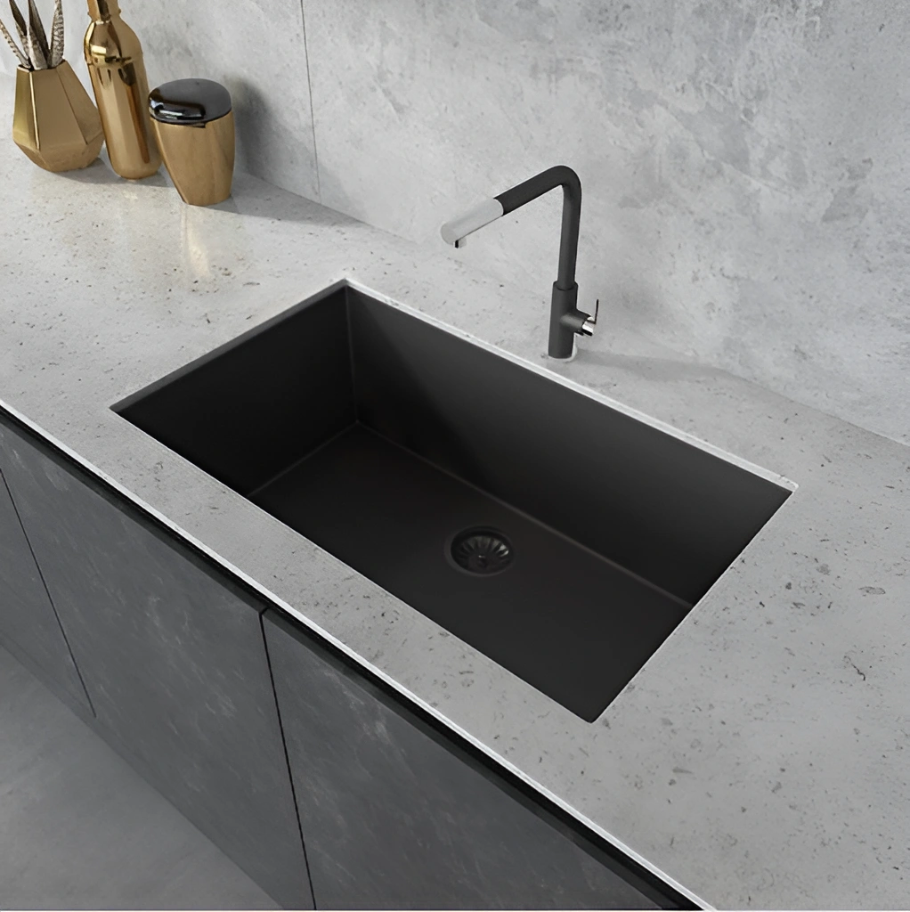 Modern black undermount kitchen sink with matching matte black faucet and stone countertop.
