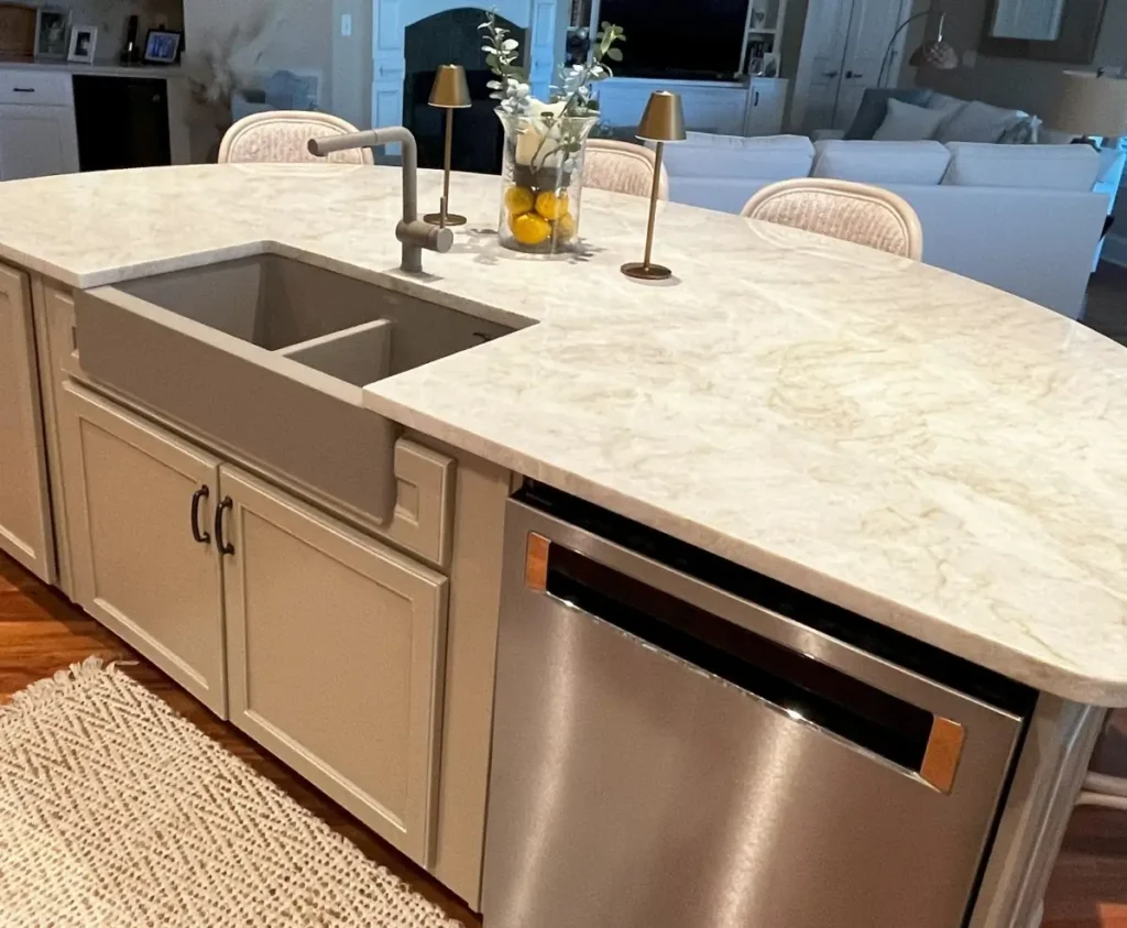 Bath & Bronze kitchen showroom display with apron sink, quartz countertop, faucet, and dishwasher.