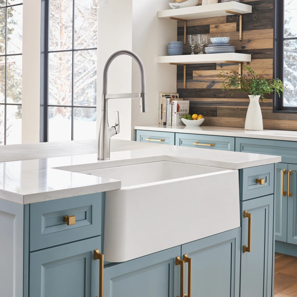 Farmhouse-style kitchen with blue cabinets, white farmhouse sink, brass hardware, open shelving, and a pull-down faucet.